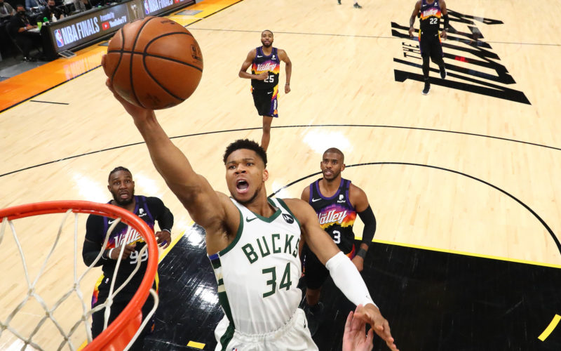 Basketball player Giannis Antetokounmpo jumping in the air to dunk a basketball during the 2021 NBA Finals