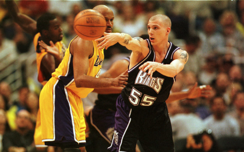 Basketball player Jason Williams throwing a pass as a member of the Sacramento Kings in a game against the LA Lakers