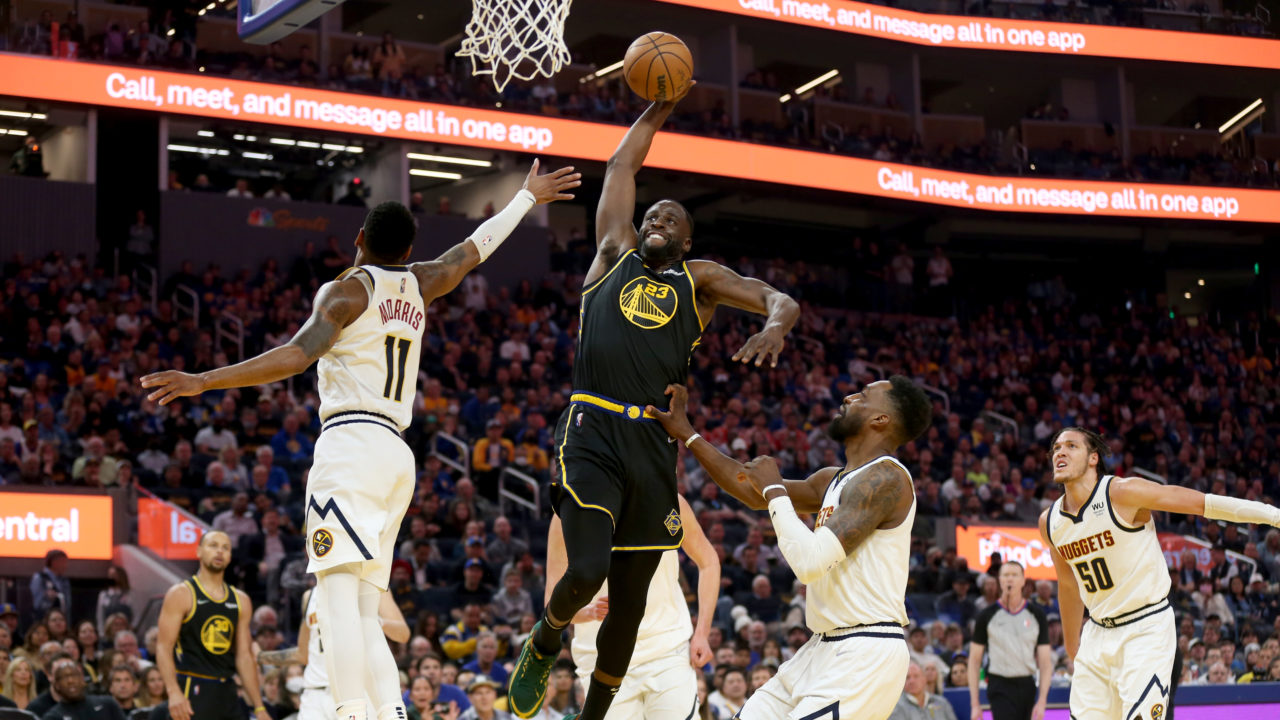Draymond Green dunking a basketball against the Denver Nuggets in the NBA Playoffs