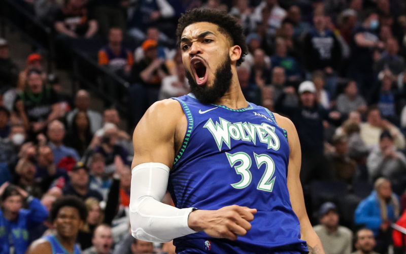 Basketball player Karl-Anthony Towns celebrating by pumping his fist and vocalizing to a surrounding crowd