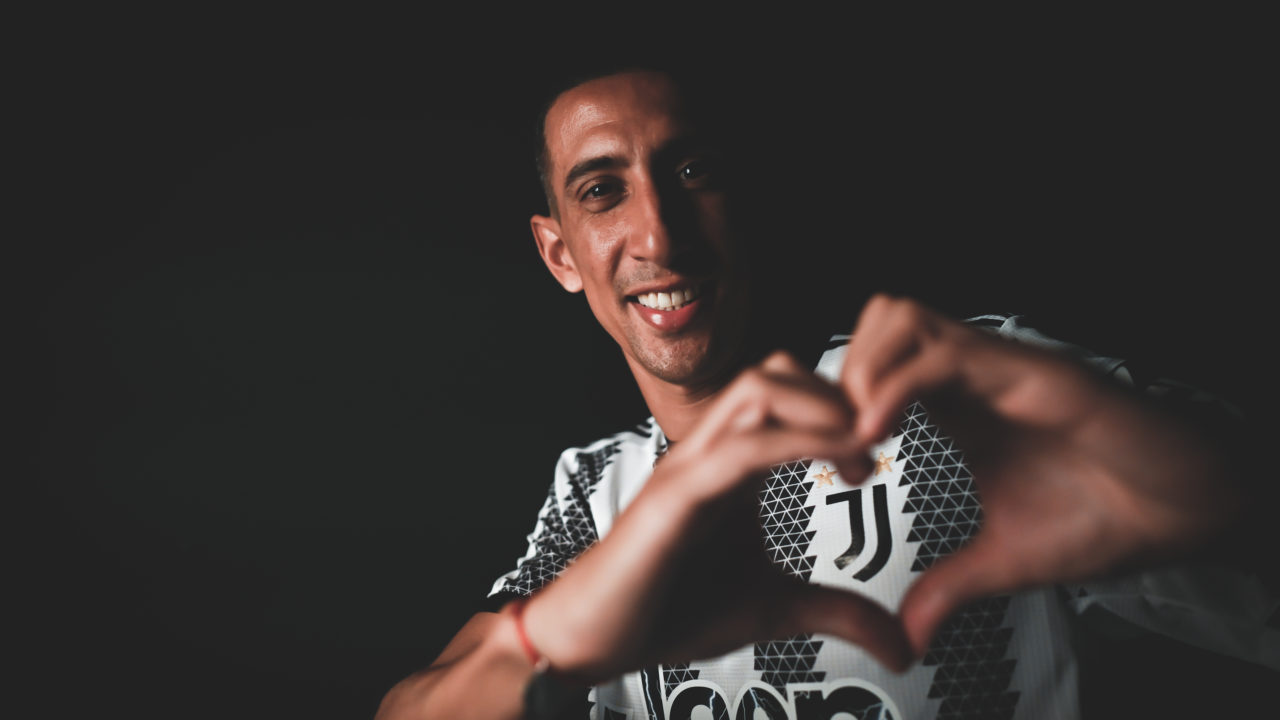 Footballer Angel Di Maria forming his hands in the shape of a heart around the Juventus team logo in the upper left corner of his shirt