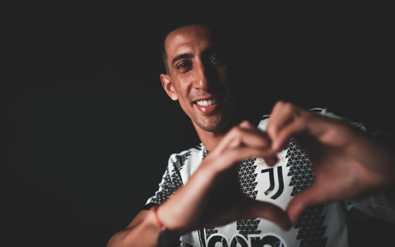 Footballer Angel Di Maria forming his hands in the shape of a heart around the Juventus team logo in the upper left corner of his shirt