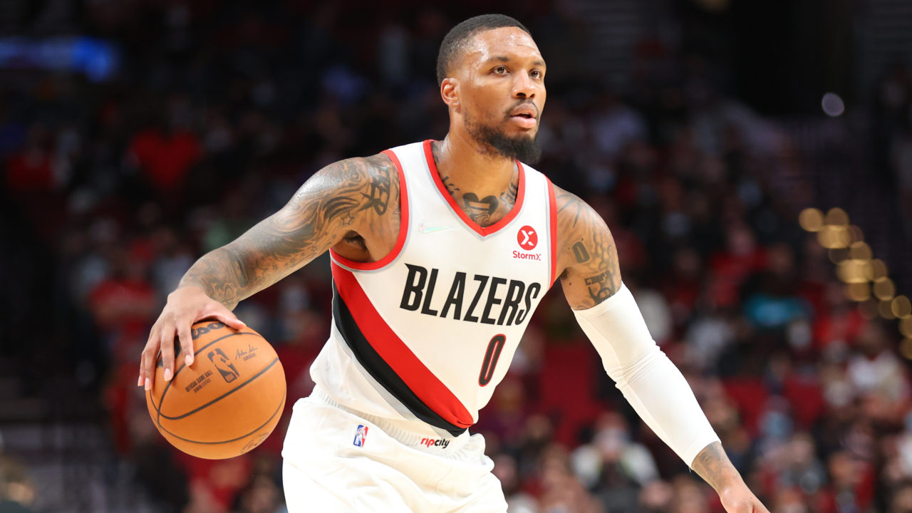 Damian Lillard dribbling a basketball with his right hand while looking downcourt