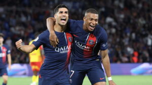 PSG footballer Kylian Mbappé celebrating with his arm around teammate Marco Asensio after a goal