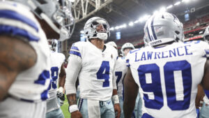 Dak Prescot celebrating with Dallas Cowboys teammates with head raised and hands by his sides