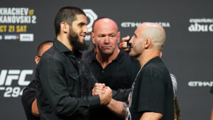 Islam Makhachev and Alexander Volkanovski staring at one another in front of Dana White